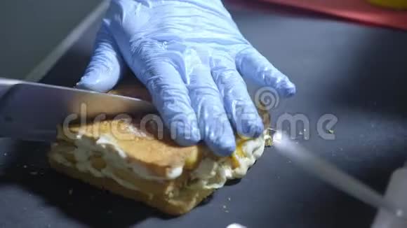 厨房里的专业厨师准备三明治把一个三明治切成四部分街头食品有害的视频的预览图