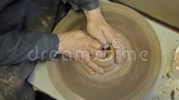 一个经验丰富的陶工用他的手创造了一个美丽的粘土花瓶视频的预览图