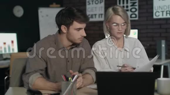 商务夫妇在夜间办公室讨论文件数据视频的预览图