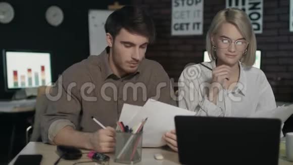 商务伙伴在夜间办公室的笔记本电脑前讨论财务报告视频的预览图