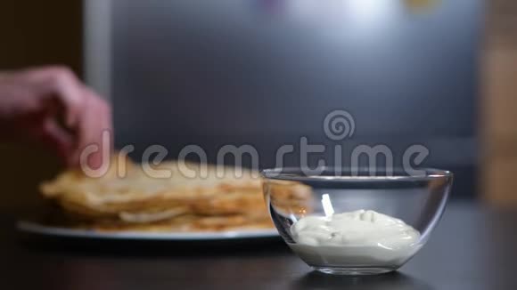 女孩把煎饼拧成一个管子蘸上酸奶油视频的预览图