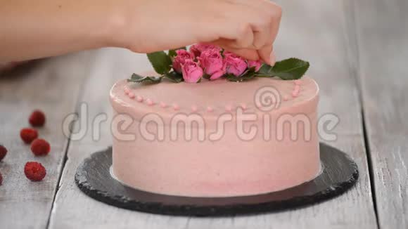 用粉色巧克力豆装饰蛋糕的过程从饼干和奶油馅中烹饪多层蛋糕视频的预览图