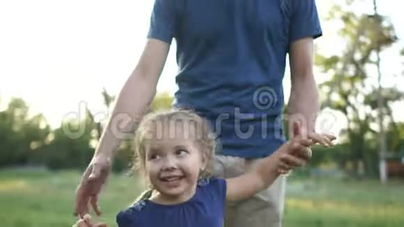 无忧无虑的小女孩被父亲在田野里旋转快乐的童年视频的预览图
