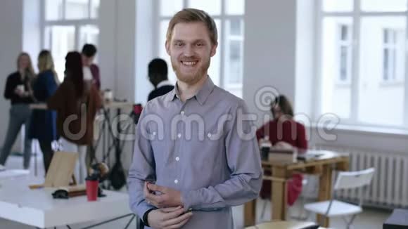 年轻自信成功的欧洲男性执行经理在现代光办公室里微笑看镜头的肖像视频的预览图