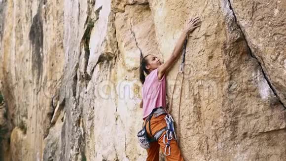 年轻健康的女性攀岩者爬上山寻找到达和抓住视频的预览图