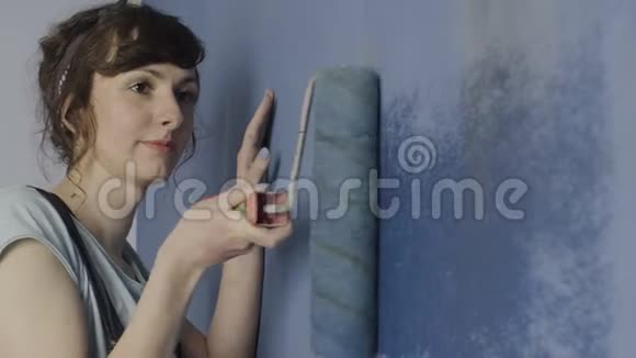 女人用油漆滚筒粉刷墙壁视频的预览图