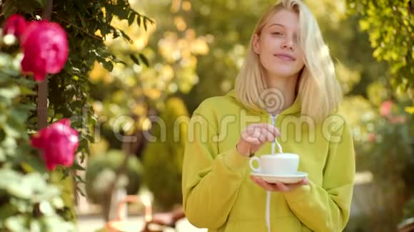 咖啡和美好的一天秋天的女人有秋天的心情阳光明媚的秋日公园里快乐的年轻女子美丽的快乐视频的预览图