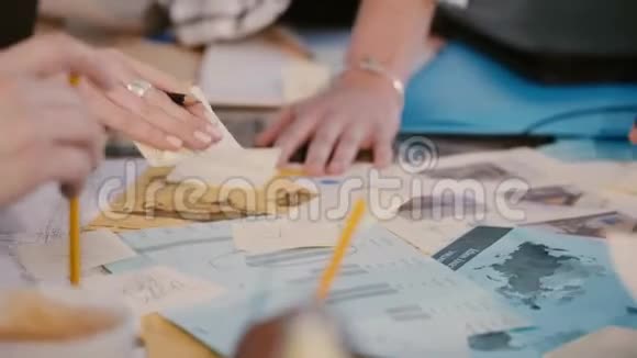 在办公桌会上的团队合作多民族商务同事的双手配合纸质笔记的特写视频的预览图