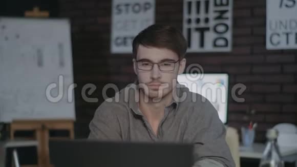 疲倦的商人在夜间办公室里伸伸懒腰在笔记本电脑前打哈欠视频的预览图