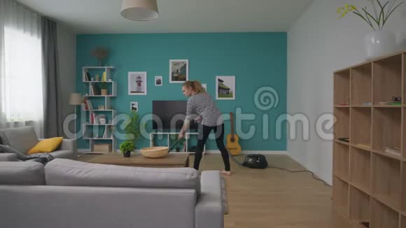 一个年轻漂亮的女人打扫她舒适的公寓视频的预览图
