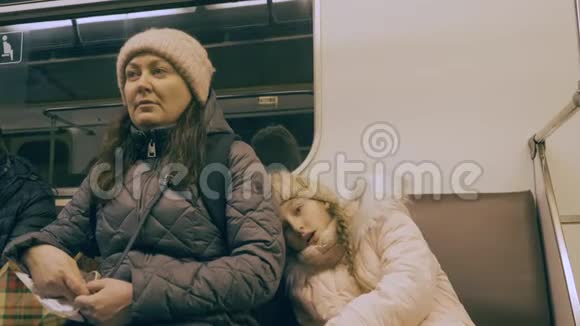 妈妈和女儿坐地铁车去疲倦的少女正在跳舞睡着了视频的预览图