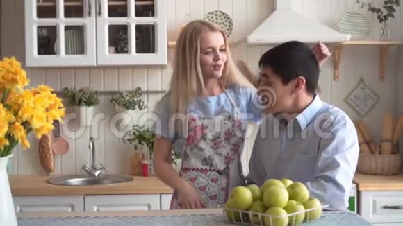 一个年轻的女人拥抱和抚摸她的男朋友他们微笑和交谈视频的预览图