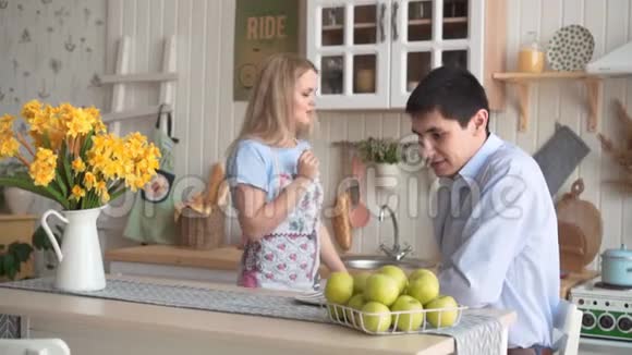 一个年轻的女人给她的男朋友一个绿色的苹果他们一起手里拿着一个苹果视频的预览图