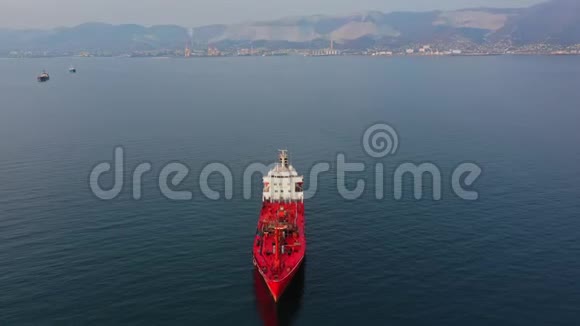 从上往下看红色超大号空货船在海上的空中镜头视频的预览图