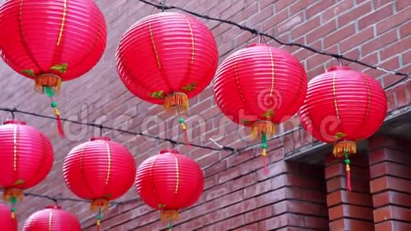 美丽的圆形红灯笼挂在古老的传统街道上中国农历新年的概念特写下面视频的预览图