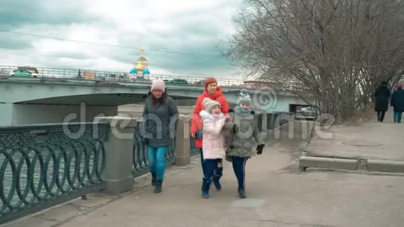 今年秋天快乐的少女和她们的妈妈一起在城市的海滨散步视频的预览图