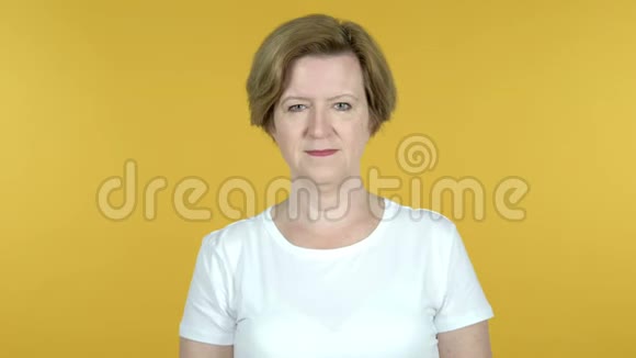 老女人用双手在黄色背景下邀请顾客视频的预览图