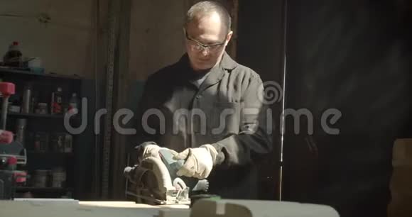 在木材厂工作的高级男师傅用锯木板打磨视频的预览图