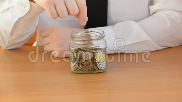 养老金储蓄概念硬币掉在玻璃罐里视频的预览图