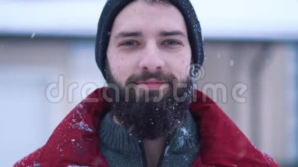 一幅平静的留着胡子的人在镜头特写中看的肖像大雪球飞来飞去砸在人的脸上是胡子视频的预览图