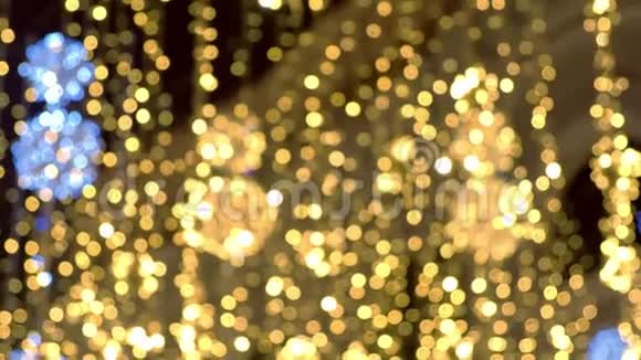 金色的圣诞灯美丽的闪烁装饰的街道模糊的背景视频的预览图