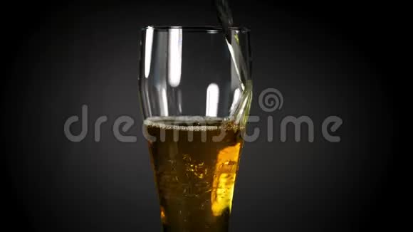 啤酒倒在黑色背景的玻璃杯里视频的预览图
