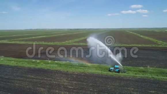 农田灌溉系统一大股水流灌溉田地一辆拖拉机正在给一块田地浇水视频的预览图