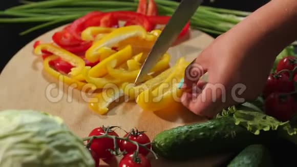一个女人把成熟多汁的黄椒切在木板上的特写镜头视频的预览图
