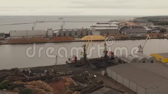 LIEPAJALATVIAJULY2019年在港口将货物装载到干货船上的船舶起重机的航空全景图视频的预览图