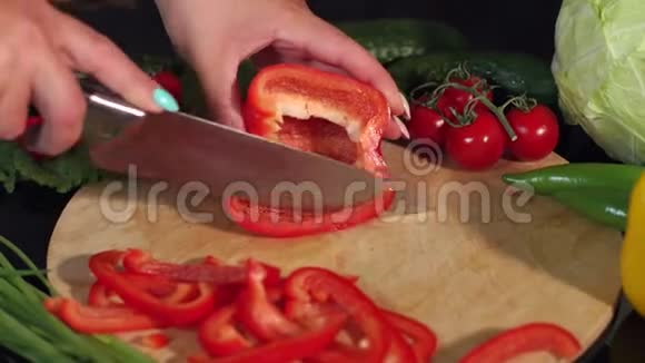 一个女人在木板上切成熟多汁的红椒的特写镜头4K视频的预览图
