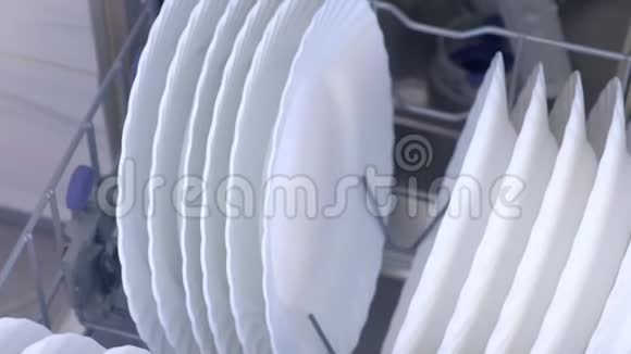 清洁厨房内置洗碗机篮子中的白色盘子和盘子视频的预览图
