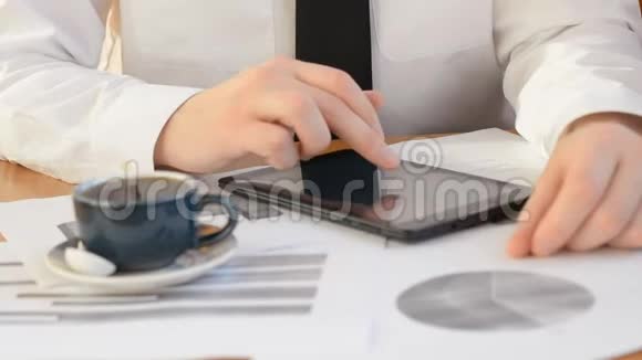 商业和办公概念在平板电脑屏幕和办公室咖啡上用图形关闭商业交易员视频的预览图