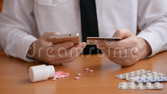 医学概念商人用手机和信用卡通过互联网购买抗抑郁药和兴奋剂视频的预览图