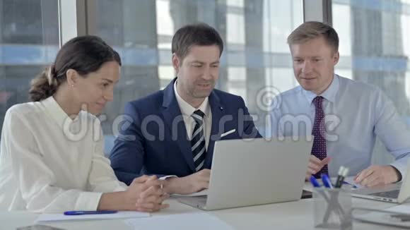 执行商务人士庆祝成功及使用办公室桌上的笔记本电脑视频的预览图
