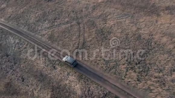 越野车黑色交叉车行驶在乡村道路鸟瞰在土路上行驶的越野车视频的预览图