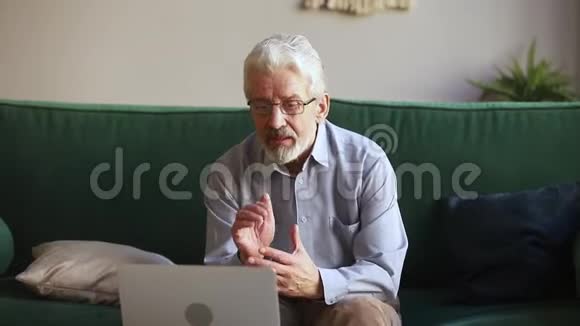 老人在说话打skype视频电话看着笔记本电脑视频的预览图