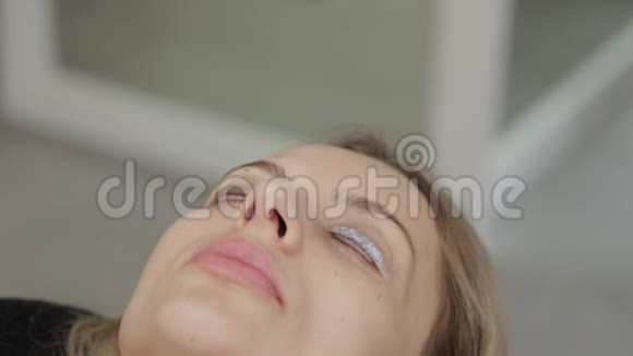 美容院的专业美容师用特殊的电影闭上客户的眼睛视频的预览图