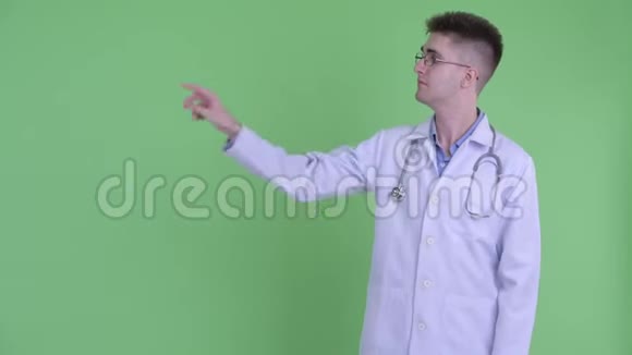 快乐的年轻人医生摸东西竖起大拇指视频的预览图