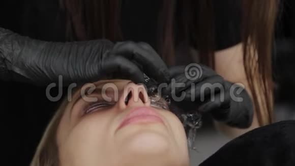 美容院的专业美容师用特殊的电影闭上客户的眼睛视频的预览图
