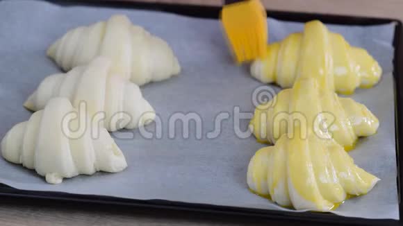 一幅面包师画蛋洗到牛角面包上将在咖啡馆里烤视频的预览图