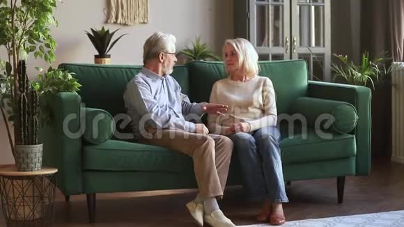 年长的一对夫妇坐在沙发上进行信任对话视频的预览图