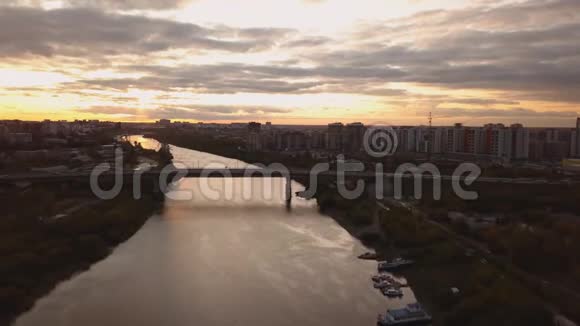 在壮观的彩色夕阳下鸟瞰河和桥的全景视频的预览图