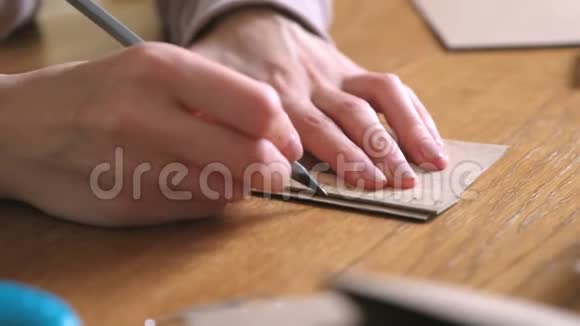 女人用牛皮纸做纸袋双手特写用尺子和铅笔测量视频的预览图