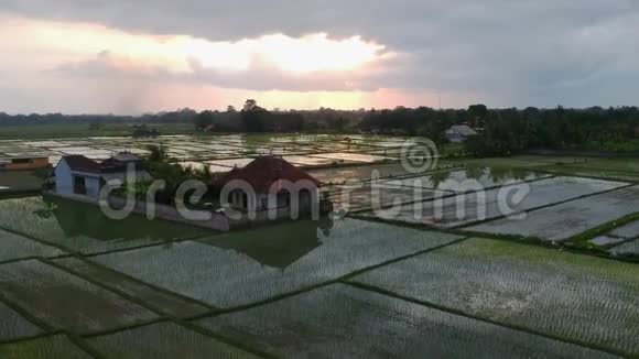 看着稻田与房子在多云的日落天空摄像头移动视频的预览图
