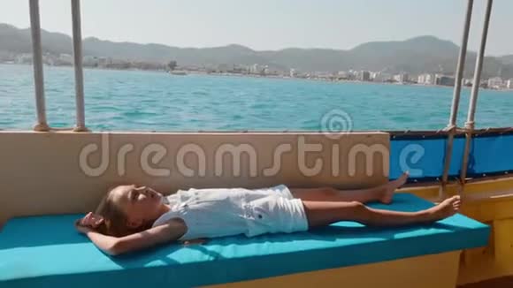 旅游女孩在海上漂流游艇上放松在海上的夏季游轮上躺在帆船上的年轻女孩青少年视频的预览图