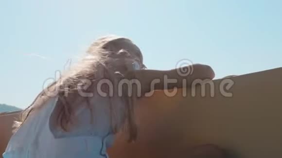 在阳光明媚的日子里少女在海上漫步快艇在青山上航行的小女孩视频的预览图