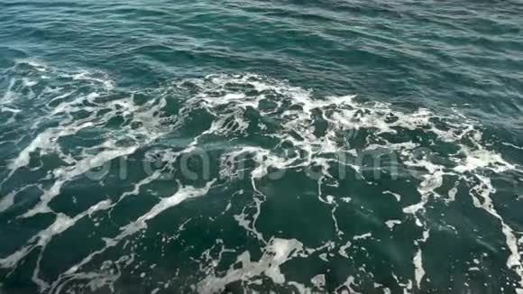 悬崖附近海面泡沫状波浪的俯视图深蓝色的大海慢动作视频的预览图