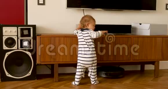 穿着工作服的婴儿站在客厅里视频的预览图