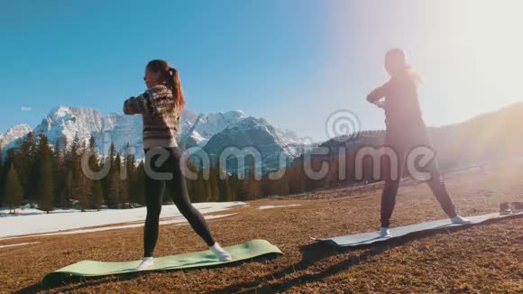 两个年轻的女人在森林和山脉的背景下伸展视频的预览图