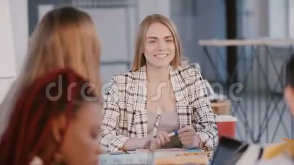 年轻漂亮成功的欧洲女公司老板说话指着同事后面的办公室会议桌视频的预览图